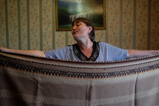 Olga shows off a blanket that was made in Estonia from Siberian wool. Her mother was deported to Siberia in 1949, but did not return with her family to their homeland in 1957, because she had two little daughters by that time. They kept ties.
